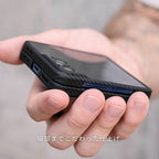 指で挟んで持った、カーボンファイバー調のGalaxy Z Flip 7 ケースを装着したスマートフォン。ケースの細部にまでこだわった作りがわかる。
