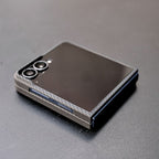 
カーボンファイバー調のGalaxy Z Flip 7 ケースを装着し、閉じた状態のスマートフォン。薄いケースの側面が確認できる。