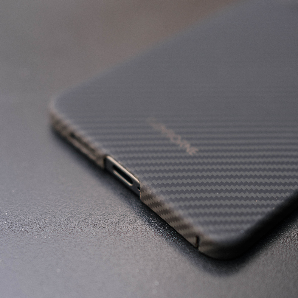 黒いカーボン調のSamsung Galaxy S25 Edge ケースを装着したスマホの、下部のポート部分をクローズアップした写真。ケースの精密なカットアウトが分かります。