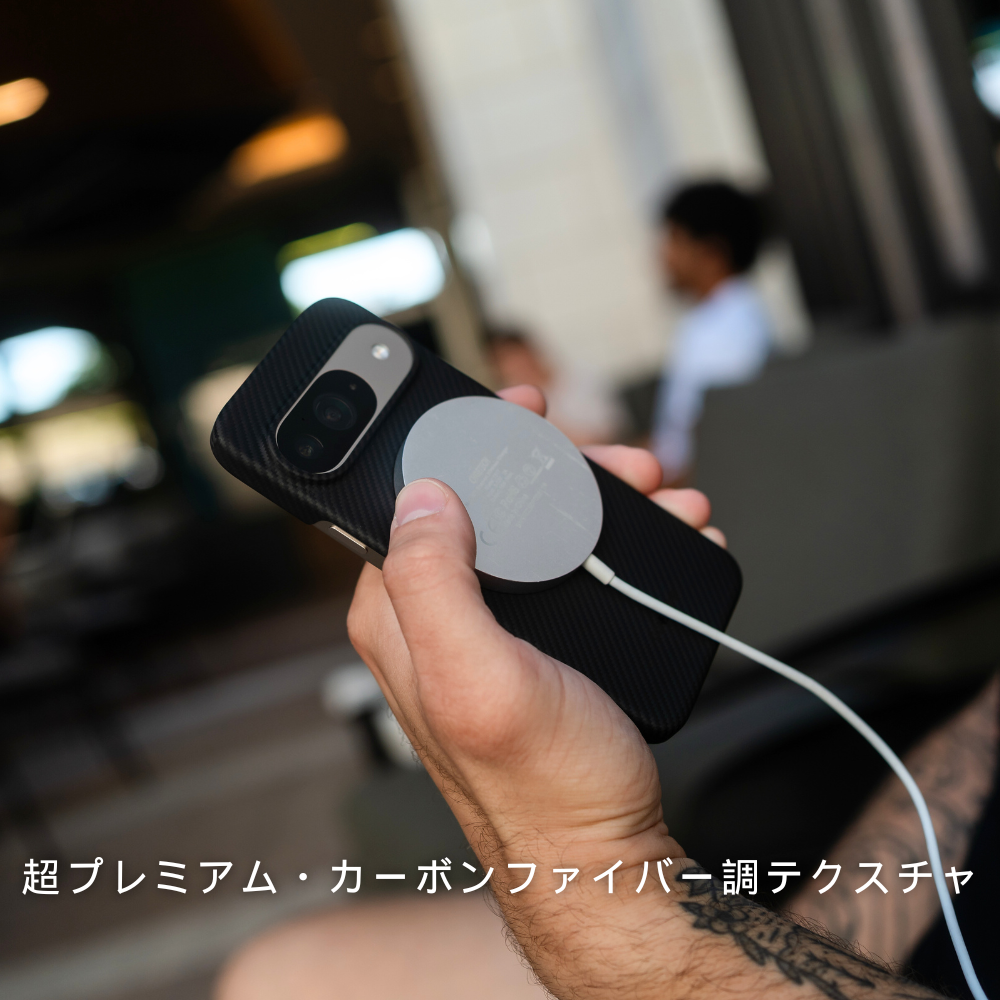  Google Pixel 10 ケースを装着したスマホに、白い円形のMagSafe対応充電器を取り付けている様子。「超プレミアム・カーボンファイバー調テクスチャ」というテキストが下に表示されています。