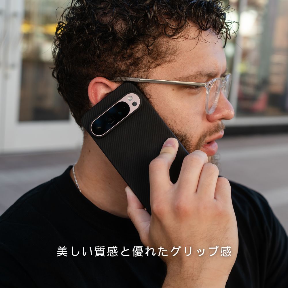 黒いカーボン調のGoogle Pixel 10 Pro ケースを装着し、電話をしている男性。下部に「美しい質感と優れたグリップ感」というテキストが記載されています。
