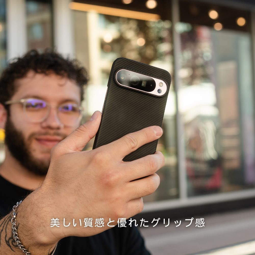 黒いカーボン調のGoogle Pixel 10 Pro xl ケースを装着し、電話をしている男性。下部に「美しい質感と優れたグリップ感」というテキストが記載されています。