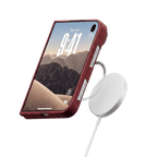 レッドのiPhone Duo ケースを装着し、MagSafe充電器でワイヤレス充電する様子
